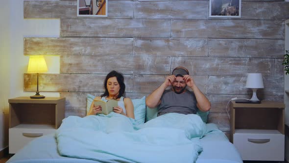 Woman Reading a Book Wearing Pajamas in Bedroom