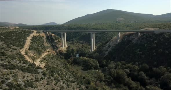 Wide aerial shot of a bridge in Bosnia and Herzegovina. the camera rises up to show the bridge