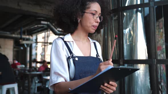 Serious female administrator writes down a list of goods