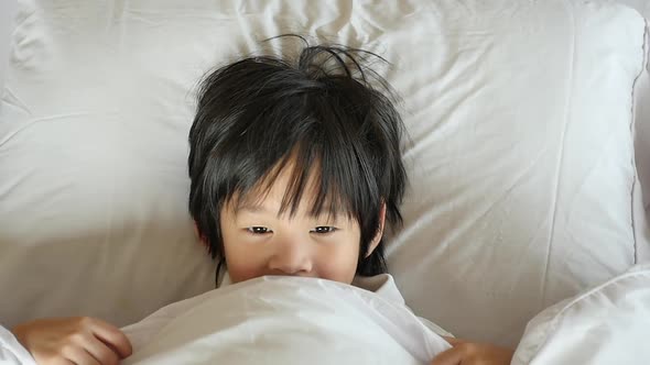 Cute Asian Child Playing Hide And Seek On White Bed Slow Motion