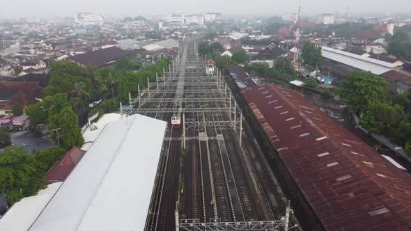 A drone flies over a train station. Aerial top view. The train is passing