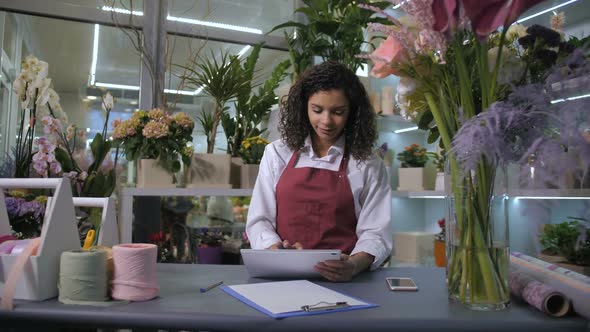 Cute Flowergirl Accepting Orders in Floristic Shop