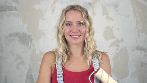 Young Attractive Woman Against the Background of a Wall During Renovations in a House or Apartment