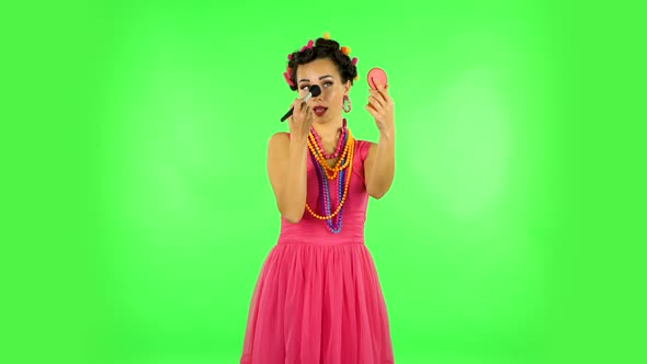 Girl with Curlers on Her Head in a Pink Dress Looking in Red Mirror and Powdered Her Nose with Big