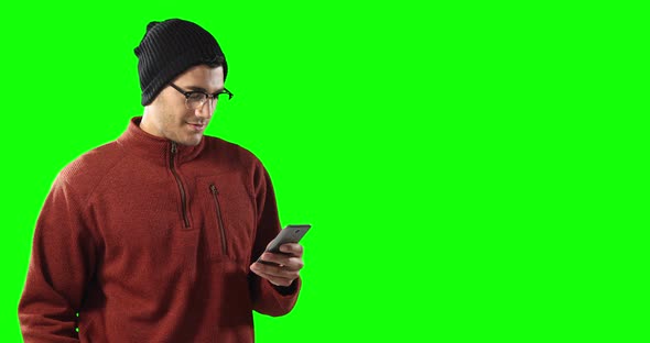 Caucasian man using a smartphone on green background