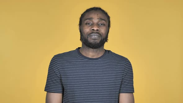 Sad Upset Casual African Man Isolated on Yellow Background