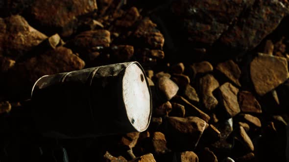 Rusty Destroyed Metal Barrel on Beach Rocks