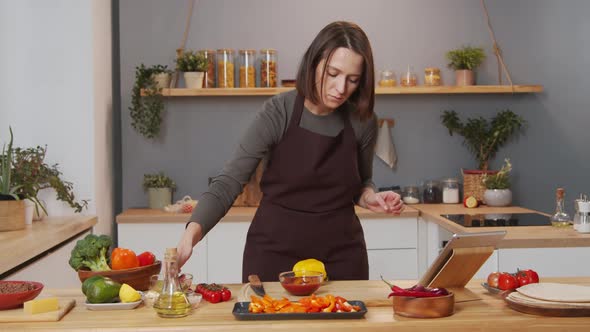 Woman Watching Video Recipe on Tablet and Cooking Food