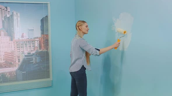 Woman Redecorates Her Office Painting the Wall