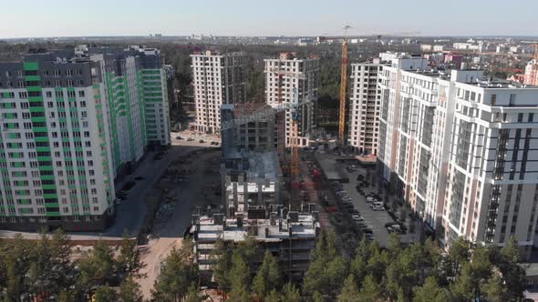 Aerial view of new multi-colored buildings in modern developed city with green parkland.