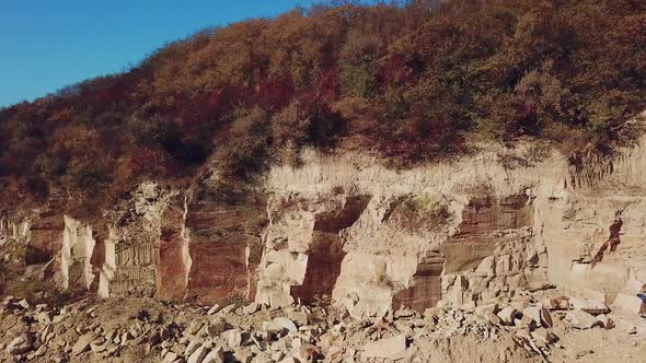 View of a large sand quarry with stones and forest. Camera motion left