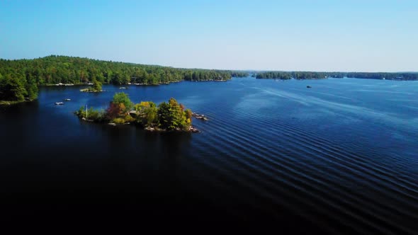 Aerial footage over a calm, blue lake and islands on a beautiful, sunny summer day