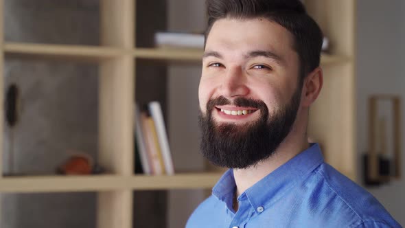 Bearded Millennial Man Turning Face to Camera and Smiling Close Up Headshot