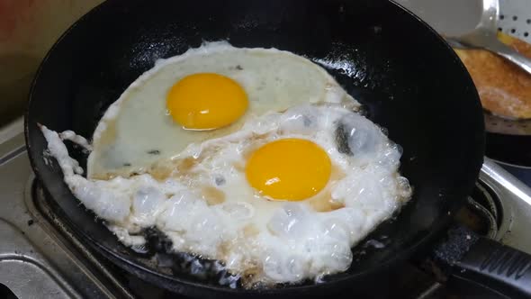 The process of frying eggs on a pan. Cooking concept