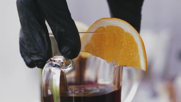 Barman Puts Glass with Delicious Red Mulled Wine on Table