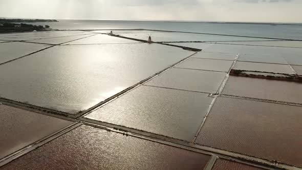 Drone view of Salt lakes at Salina Grande, Sicily, Italy. Pull out shot.