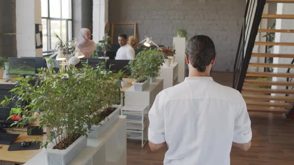 Rear of Man Walking in Office