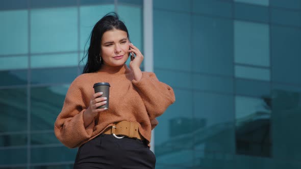 Happy Hispanic Woman Standing Outdoors Drinking Coffee of Paper Cup Responding to Friendly Call