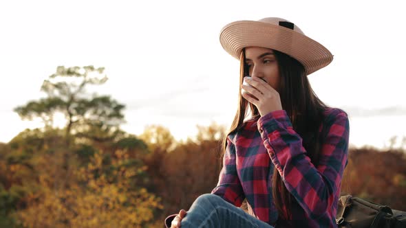 A Young Woman is Drinking Hot Tea