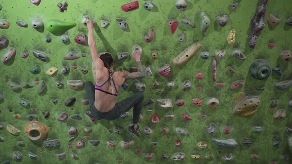 Strong Athletic Woman Lets Herself Fall in Front of Rock Wall in Slow Motion