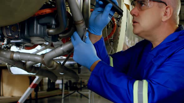 Engineer examining an aircraft engine in hangar 4k