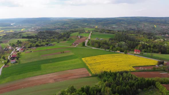 Aerial Drone View of Green Fields, Hills and Trees in a Village with Small Houses. Poland