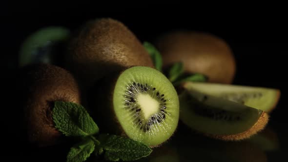 Delicious Juicy Fruit Kiwi and Mint Lie on a Black Table