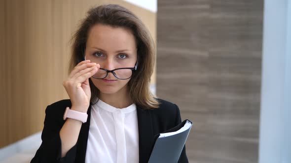 Portrait Of Beautiful Business Woman Wearing Wireless Earphones in Office Hall