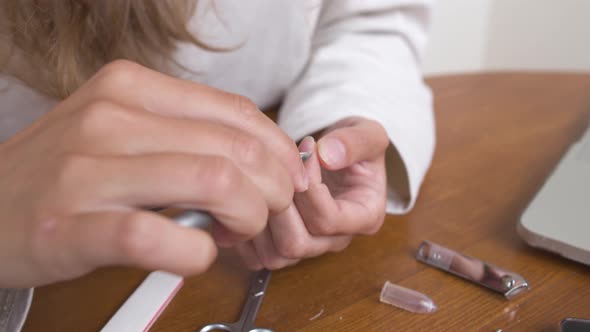 Closeup of a Young Caucasian Woman Doing a Manicure By Cutting Off Nails and Cuticles at Home