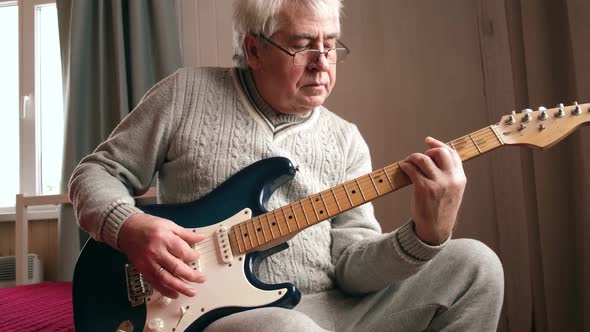 Senior Man is Playing Guitar