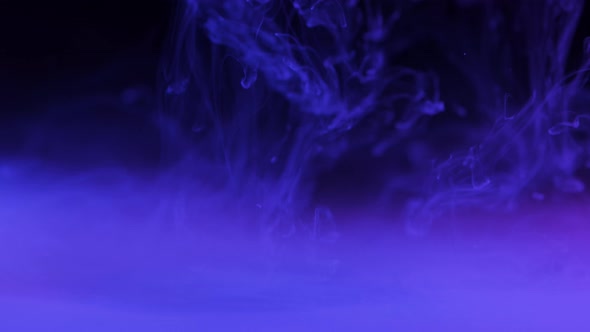 White Ink in Water on Dark Background With Hue of Lavender Forming Smoke