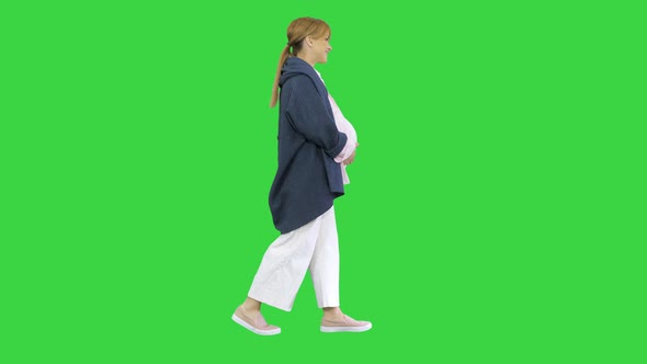 Happy Pregnant Blonde Lady Walking on a Green Screen, Chroma Key.