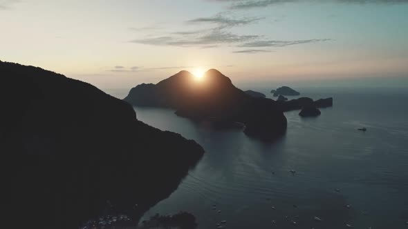 Aerial Sunrise Over Mountain Island Silhouette at Sea Bay