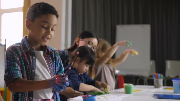 Cute Diverse Kids Painting with Hands at Lesson
