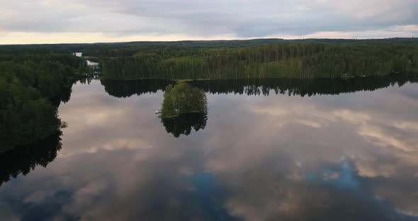 An island in the middle of a glassy lake during sunset