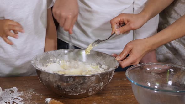 Children Helping Parents To Preparing a Dough in Domestic Kitchen