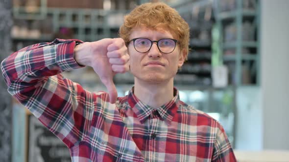 Young Redhead Man with Thumbs Down Gesture
