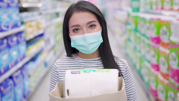 Young Asian woman in medical mask grocery walk toward camera shot, at supermarket