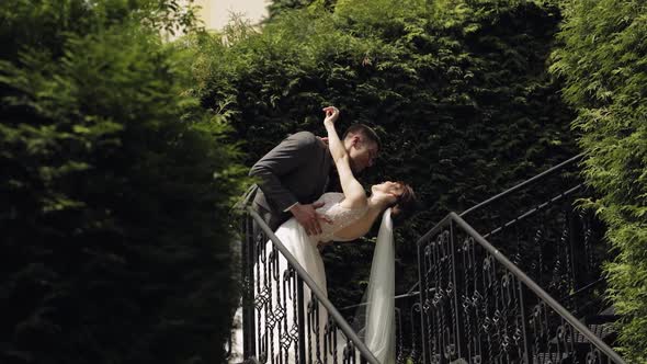 Newlyweds Caucasian Groom with Bride Stay on Stairs in Park Wedding Couple Man and Woman in Love