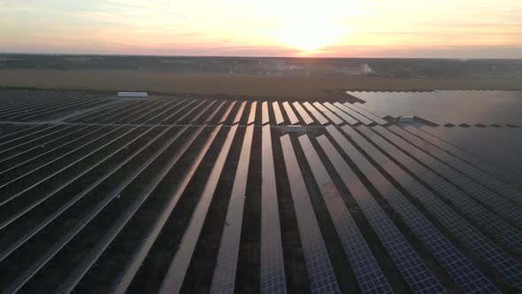 Aerial Drone View Into Large Solar Panels at a Solar Farm at Bright Sunset. Solar Cell Power Plants
