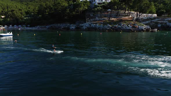 Drone view of kid doing water ski in the sea.