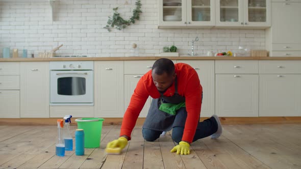 Industrious African Male Wiping Floor at Home