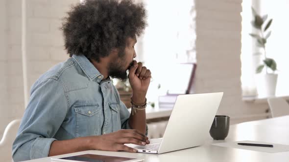 Sick Creative African Man Coughing and Working on Laptop