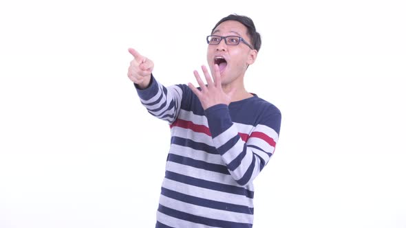 Happy Japanese Hipster Man Pointing Finger and Looking Surprised