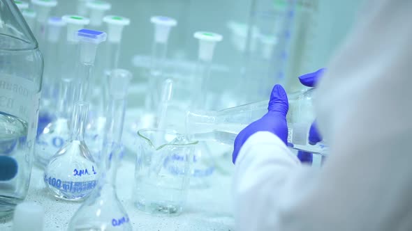 Doctor Chemist Mixing Pouring Transparent Liquid Chemical in Flask on Table Spbd