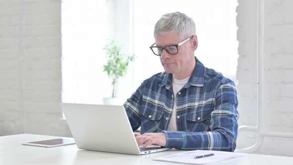 Focused Casual Middle Aged Man Working on Laptop