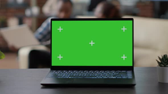 Laptop Display with Green Screen Template on Office Desk