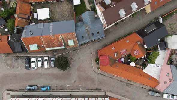 Old historic buildings of Ystad city with colorful rooftops, aerial ascend top down view