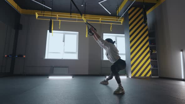 Sporty Woman Doing TRX Exercises in the Gym