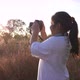 Girl standing in meadow and taking a picture by camera - VideoHive Item for Sale
